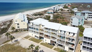 Hotel de vários andares com varandas, situado perto de uma praia com vista para o oceano.