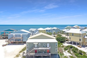 Une propriété située en bord de mer, composée de plusieurs bâtiments à étages, dont certains sont dotés de balcons, et offrant une vue dégagée sur l’océan.