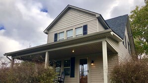 A two-story house with a front porch, a chimney, and a small front yard. - Hot tub, Campfire ring and great location! (Harpers Ferry)
