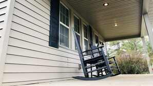 A covered porch with a rocking chair and a ladder. - Hot tub, Campfire ring and great location! (Harpers Ferry)