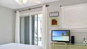 A room with a bed, a desk with a computer monitor, a telephone, and a sign reading "SEASIDE BUNGALOW". - Pools, Play Ground, Beach Access Barrier Dunes 426 - 62 Beach House Too (Cape San Blas)