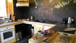 Une cuisine moderne dotée d’un plan de travail en bois, d’un four encastré, d’un évier et d’une cuisinière.