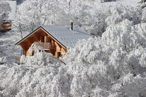 A wooden cabin with a balcony, surrounded by snow-covered trees. - Chalet - NOTRE DAME DU PRE (Notre-Dame-Du-Pré)