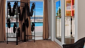 Ein Zimmer mit Blick auf einen Pool und einen Balkon mit bunten Geländern.
