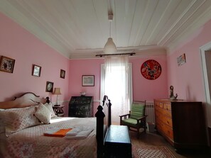 A bedroom with a bed, dresser, chair, and a desk. - Beautiful family house with pool in the center of a typical village of Portugal (Vila Nova de Poiares)