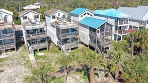 Une propriété située en bord de mer, comprenant plusieurs bâtiments, notamment une grande maison avec un toit bleu et une plus petite maison dotée d’un balcon.