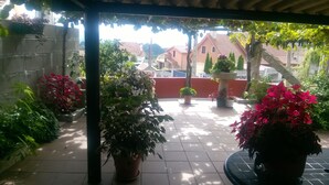 A covered patio area with potted plants and a tiled floor. - "EIRA VELLA" Holiday house, (from € 30 day / month). (Pontevedra)