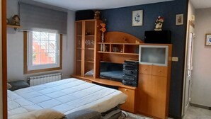 A bedroom with a bed, a wooden wardrobe, a television, and a window. - "EIRA VELLA" Holiday house, (from € 30 day / month). (Pontevedra)