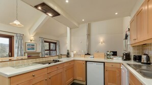 Una cocina moderna con armarios de madera, lavavajillas y varios electrodomésticos.