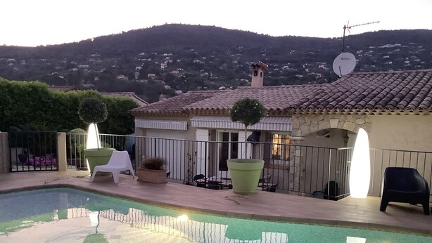 A swimming pool with a wooden deck, surrounded by potted plants and outdoor furniture. - PRETTY PROVENCAL VILLA WITH POOL (Le Tignet)