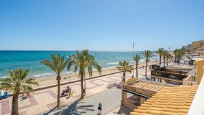 Eine Strandpromenade mit Palmen, einem Strand und einem Gebäude, auf dem das Schild "Bucanera Mix" steht.