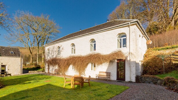 A white building with a gravel driveway and a grassy lawn. - Stables East -  a semi-detached cottage that sleeps up to 6 guests (Oban)