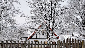 Une clôture en bois recouverte de neige, sur laquelle est accrochée une pancarte indiquant « Casa Susana ».