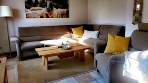 Un salon avec un canapé marron, une table basse en bois et une lampe.