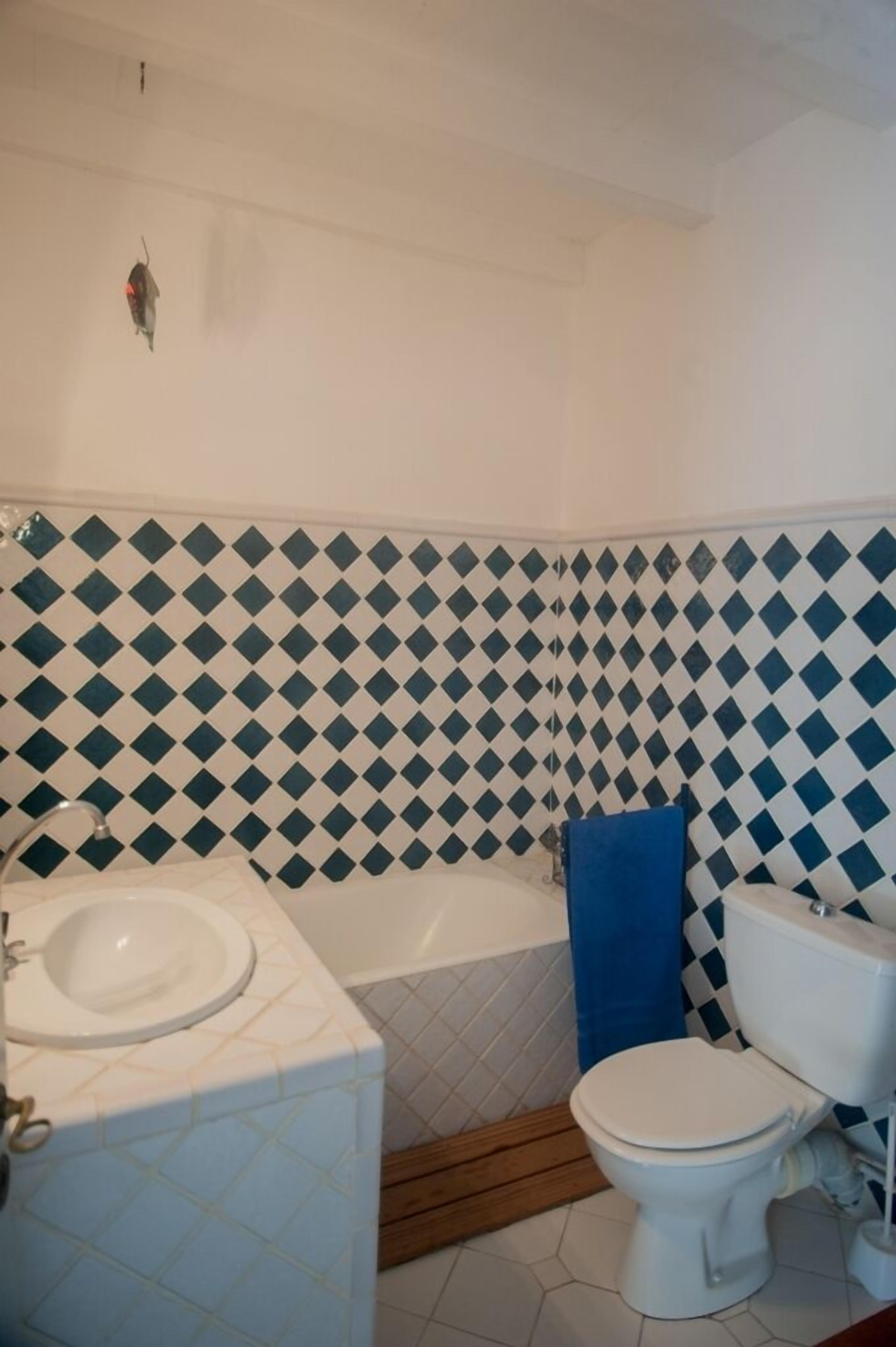 A bathroom with a white sink, a bathtub, and a toilet.
