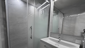 A modern bathroom with a glass-enclosed shower, a white sink with a single faucet, and a large mirror above the sink. - RESIDENCE 2-235 - Village-center studio, close to the slopes - Wi-Fi - Garage (La Clusaz)