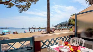 Ein Tisch am Strand mit Blick auf den Strand und Boote.