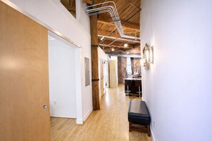 A modern interior with a wooden floor, white walls, and exposed ductwork.