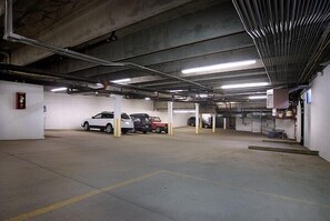 Un parking à plusieurs niveaux où sont garées plusieurs voitures.