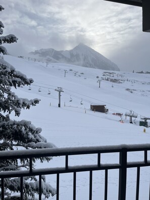 Un paysage de montagne enneigé avec des remontées mécaniques et un chalet.