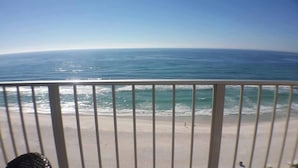 A balcony with a view of the ocean and beach.