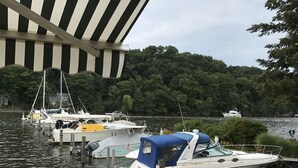 A marina with boats docked, a covered area, and a forested background. - Beautiful home in Picturesque setting just steps from Lake Michigan! (Fennville)