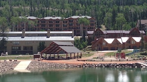 Eine Lodge mit mehreren Gebäuden, einem Pool und einer Bergkulisse.