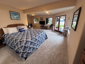 Une chambre à coucher avec un grand lit, un bureau, une chaise et un téléviseur.