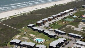An aerial view of a coastal hotel with multiple buildings, a swimming pool, and a beach in the background. - Price DROP!August 28-29 weekendprice has dropped! Ocean View 2nd floor/2bd 2bath (Port Aransas)