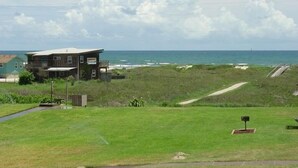 A coastal property with a large house overlooking the ocean, a grassy area, and a pathway leading to the beach. - Price DROP!August 28-29 weekendprice has dropped! Ocean View 2nd floor/2bd 2bath (Port Aransas)