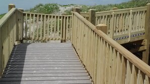 A wooden boardwalk leading to a beach with a wooden railing on both sides. - Price DROP!August 28-29 weekendprice has dropped! Ocean View 2nd floor/2bd 2bath (Port Aransas)