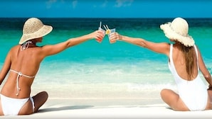 Two people sitting on a beach facing the ocean, holding drinks. - 4th Floor! ☼☼❀❀ 2BR/2BA,Sleeps 6,Handicap Acc,Living & Mstr Rms Facing The Beach (Panama City)