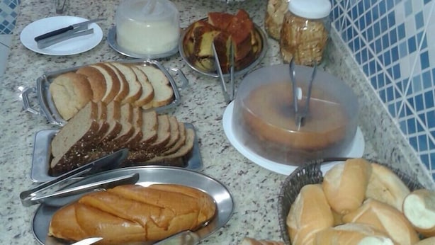 A buffet spread with various food items including bread, fruits, and a coffee station. - Hotel Porto Real (Porto Real)