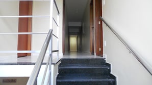 A staircase with a metal railing leading to a landing. - Hotel Porto Real (Porto Real)