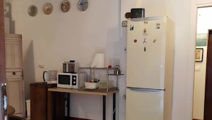 A compact kitchen with a microwave, refrigerator, and wooden cabinets. - Casa Di Adel (Venice)
