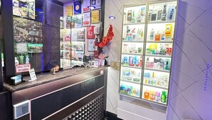 Un'area di accoglienza con un bancone in legno, una vetrina che espone diversi articoli e una parete con targhe e certificati.