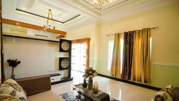 A spacious living area with a sofa, a coffee table, and a decorative vase. - DanSam House (Davao)