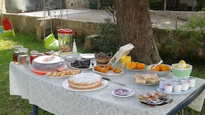 A picnic table set outdoors with various food items and drinks. - B&B Li Cuti (Tiggiano)