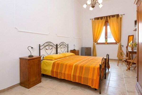 Cozy retreat with a single bed, nightstand, and window with a view.