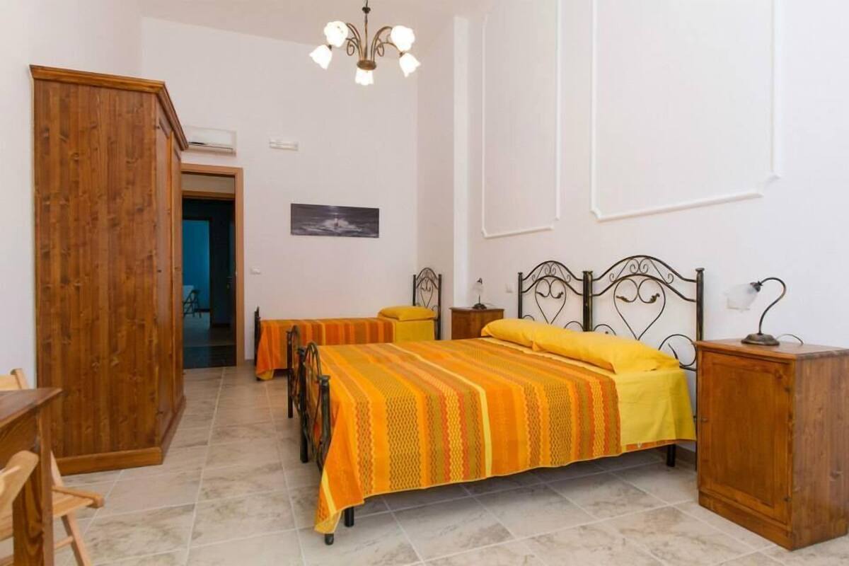 Un dormitorio con cama, muebles de madera y una araña.