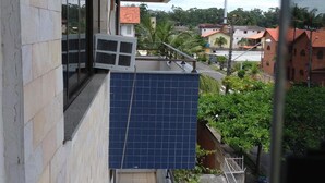 A multi-story building with a balcony, a window, and a view of the surrounding neighborhood. - Residencial Baleia Franca (Florianópolis)