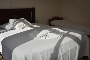 A hotel room with two single beds, each with white linens and pillows. - Residencial Baleia Franca (Florianópolis)