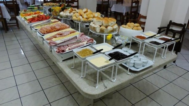 A buffet with various food items and condiments. - Residencial Buenos Aires (Florianópolis)