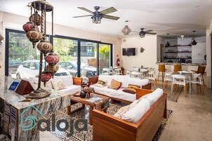 Amplia sala de estar con un conjunto de sofás, una mesa de centro y una lámpara decorativa.