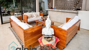 A modern living area with wooden furniture, a decorative statue, and a patterned rug. - Zendero Tulum (Tulum)