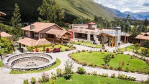 Un resort con diversi edifici, un patio circolare in pietra e montagne sullo sfondo.