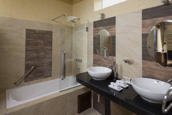 A modern bathroom with a bathtub, two sinks, a glass shower enclosure, and a large mirror. - Intiterra The Luxury Apart Hotel (Urubamba)