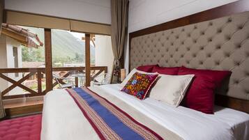 Een slaapkamer met een groot bed, uitzicht op de omgeving en een balkon.