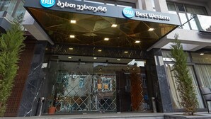 Une entrée d’hôtel moderne, avec une enseigne « Best Western » bien visible, une façade en verre et un design géométrique.