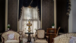 A classic interior with a marble coffee table, two upholstered armchairs, a sofa, and a vintage radio. - The Bevin House Bed & Breakfast (East Hampton)
